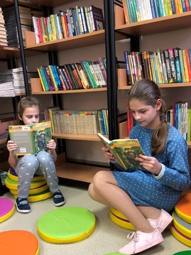 dziewczynki czytają książki w bibliotece.jpg